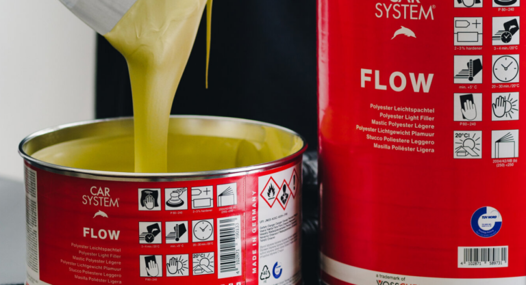 Two CARSYSTEM Flow Putty cans, one opened with a spatula lifting smooth, flowing putty.